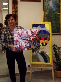 Kobieta stoi trzymając obraz