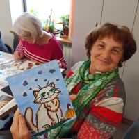 Kobieta siedzi i trzyma obraz