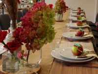 Stół zastawiony zastawą z jabłkiem na każdym talerzu